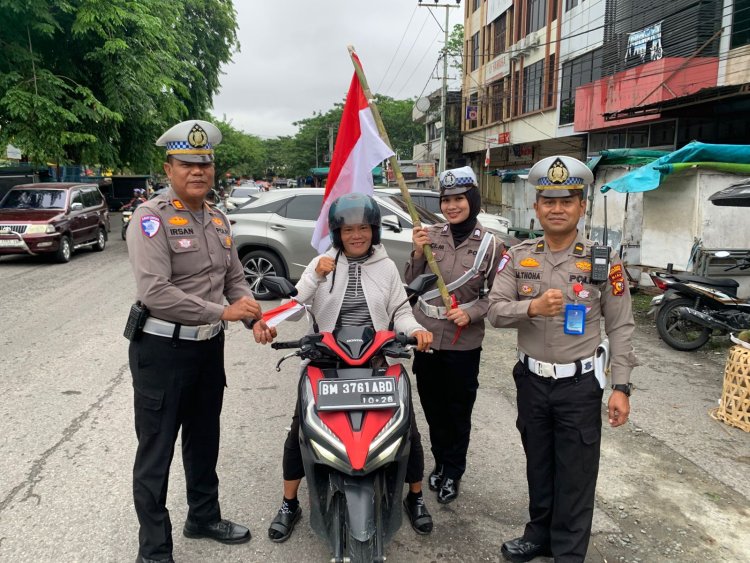 Satlantas Polresta Pekanbaru Bagikan Bendera Merah Putih Kepada Pengendara